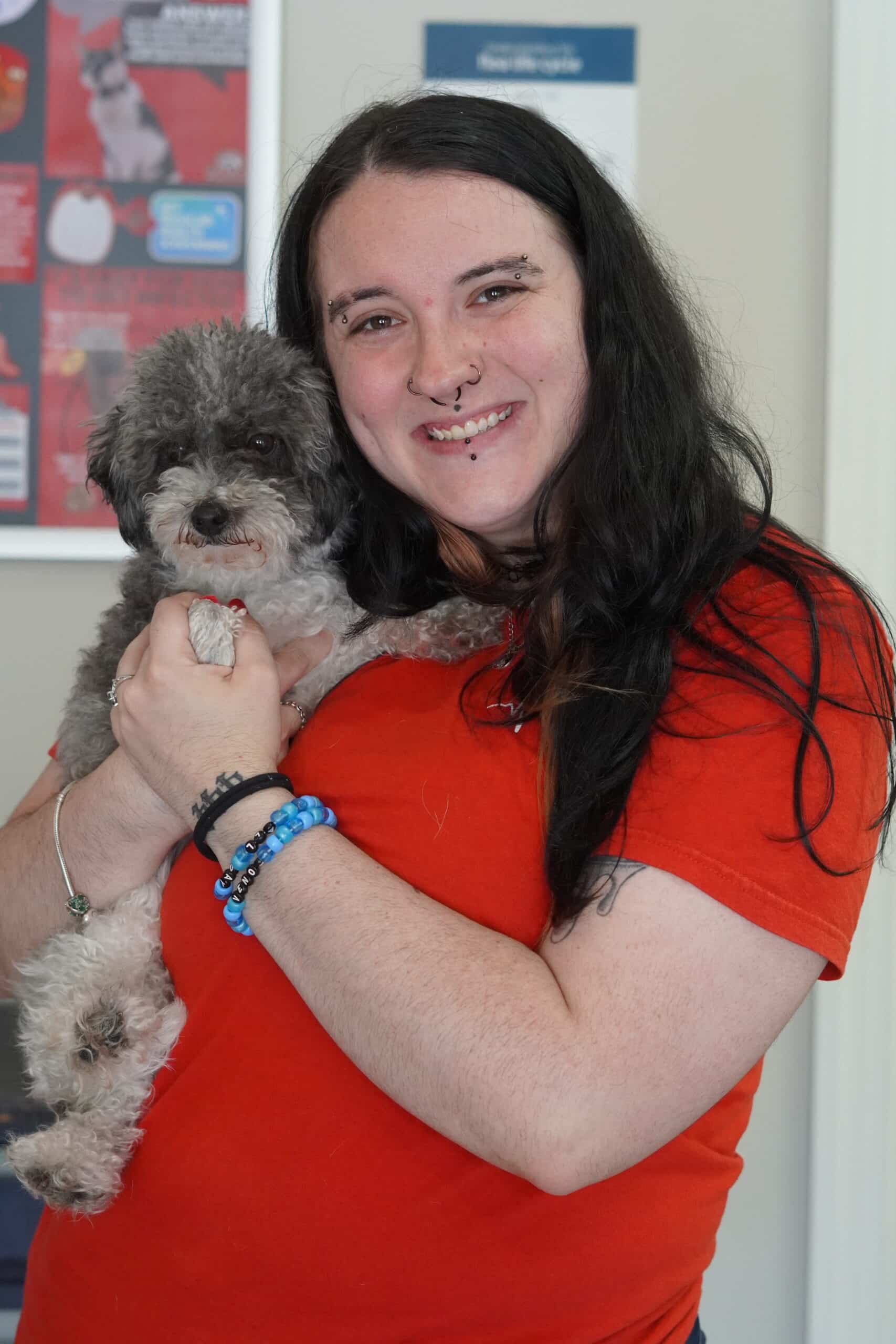 DSC02586 A woman gently holds a small dog in her arms